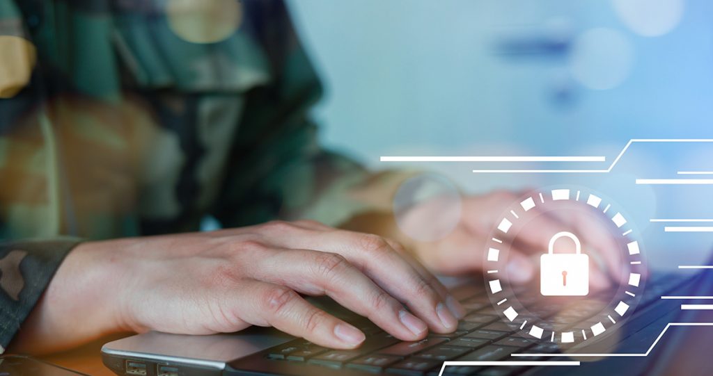 person in military uniform using a laptop